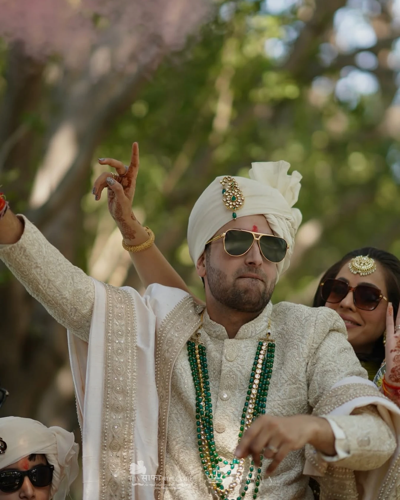Groom in an ivory wedding safa with emerald jewellery for Awas
